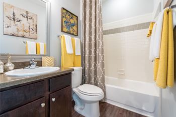 A bathroom with a white toilet, sink, and bathtub.